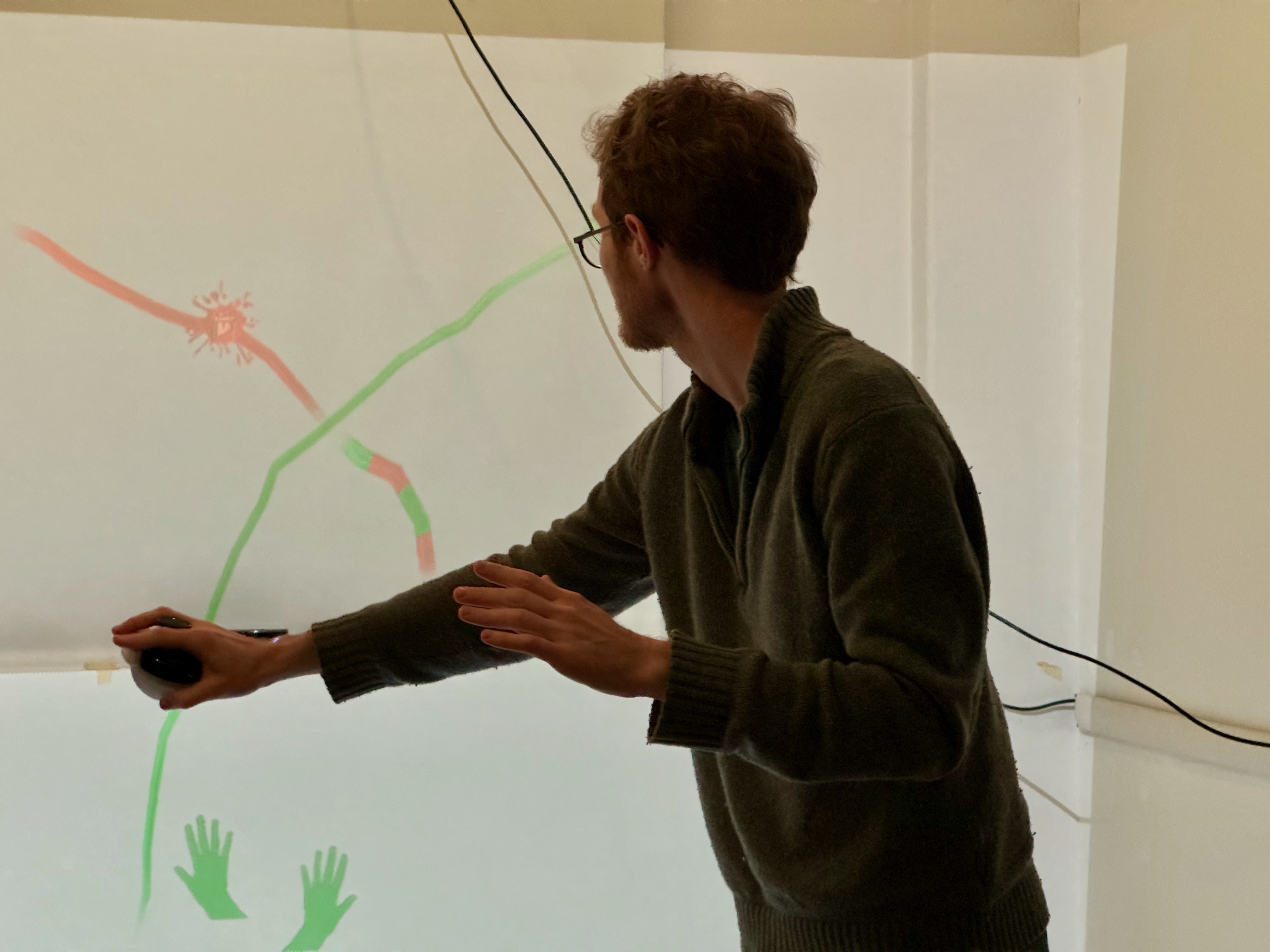 A participant painting on the projected canvas with the MusicTraces controller