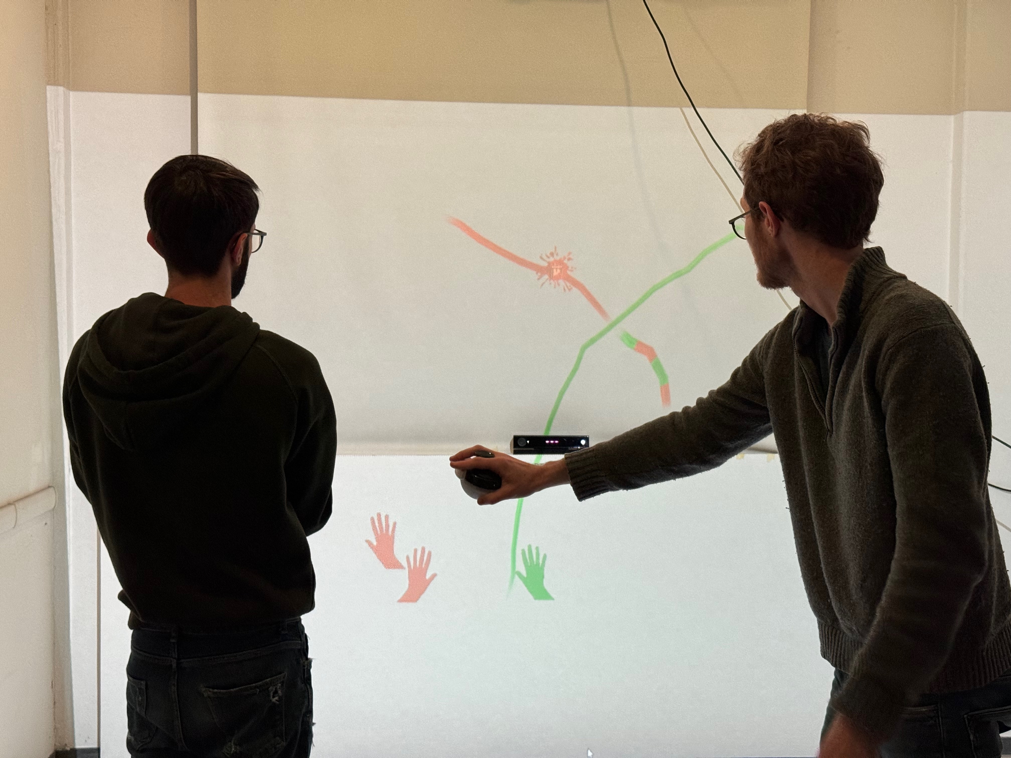 Two participants painting together on the MusicTraces projected canvas